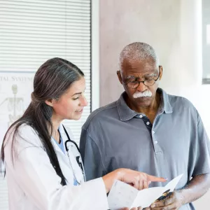 A Doctor Goes Over a Brochure with Her Senior Patient