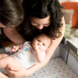 Mother and Father Laying Child Down in Crib
