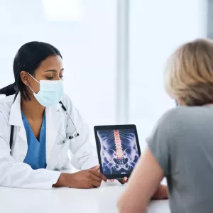 Doctor With Patient Showing X-rays