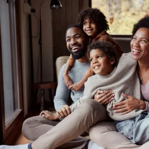 A happy African-American family looking out the window