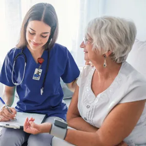 Nurse checking patient's blood pressure.