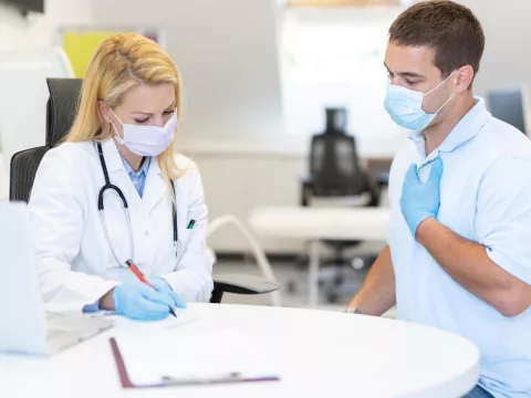 A Doctor Goes Over Details of a Case with the Patient while Sitting at a Round Table.