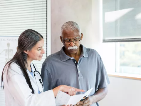 A Doctor Goes Over a Brochure with Her Senior Patient