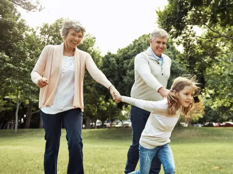 Senior Couple Playing With Grandchild in Park