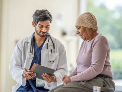 Doctor explaining to an older woman cancer patient her test results.