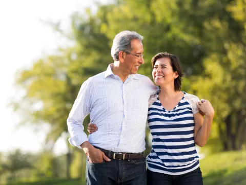 Older couple walking outdoors smiling at each other