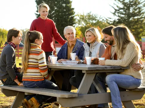 Family sitting outside at a picnic table