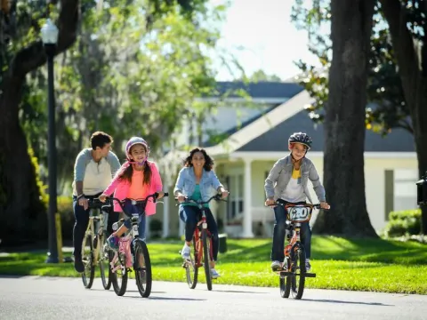 A family rides their bike in a neighborhood.