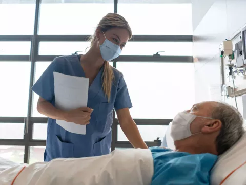 Nurse Checks on an Patient in His Hospital Room.