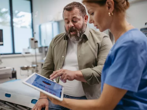 A male patient talks with a female doctor about his test results.