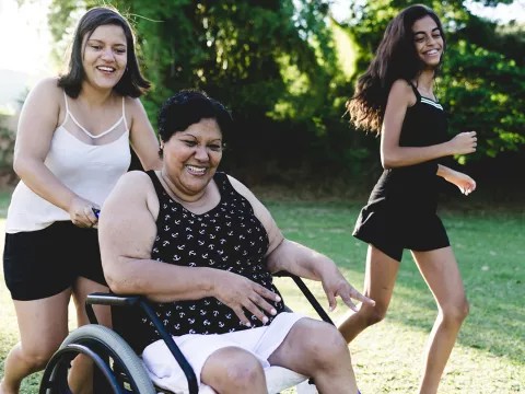 Woman in wheelchair with daughters outside