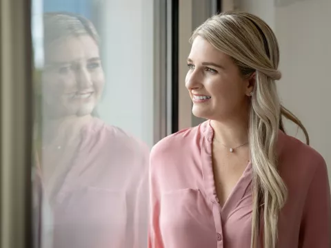 Female patient in office looking out through window.