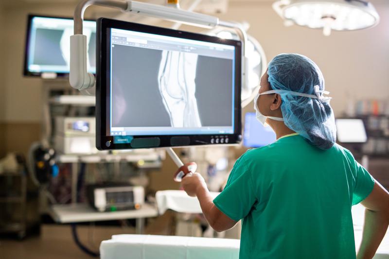 doctor in scrubs examining an x-ray in a surgical room