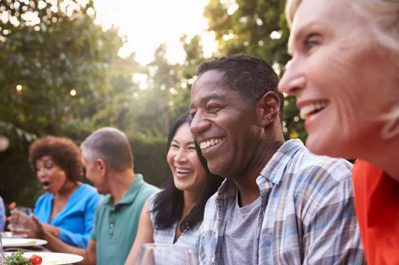 Friends sitting outdoors at a table during a dinner party.