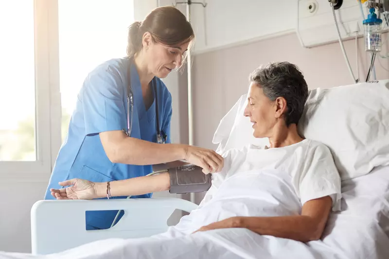 Nurse and patient in hospital room.