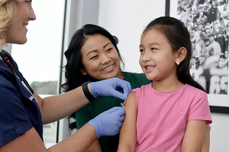 A Nurse Puts a Band Aid on a Child Patient after an Injection