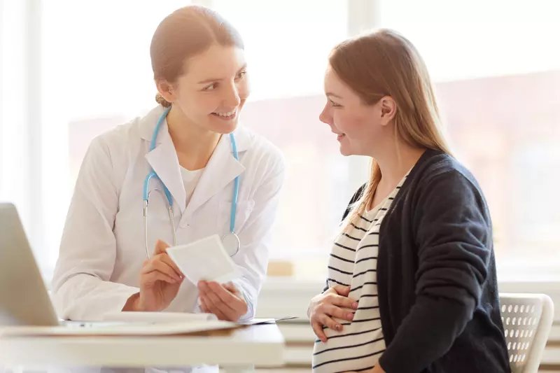doctor speaking with pregnant woman