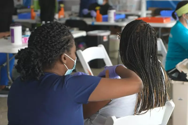 A nurse administers a vaccine to a patient at a community vaccination event