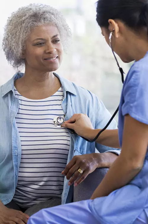 Female Doctor Listening to Woman's Heart